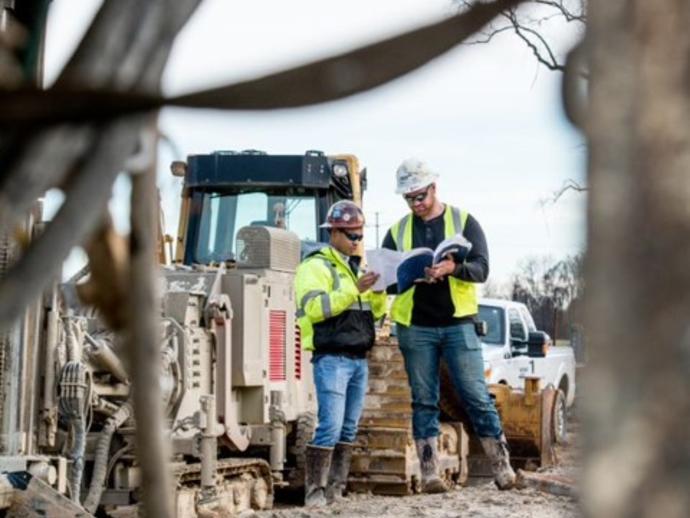 Keller Mitarbeiter mit Plan auf Baustelle